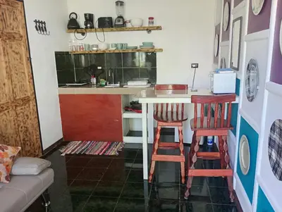 a kitchen with two stools and a table in a room at Kristel Rooms in Quepos