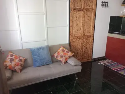 a couch with pillows on it in a room at Kristel Rooms in Quepos