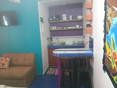 a kitchen with a bar with a couch and a table at Kristel Rooms in Quepos