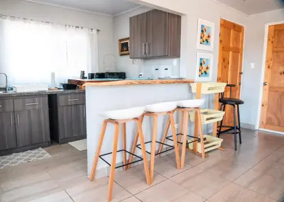 a kitchen with a counter and some stools at Fruta mango # 1 in Playa Guacalillo