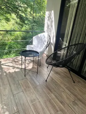a patio with a chair and a table on a porch at Ona Casita 1 in Cuajiniquil