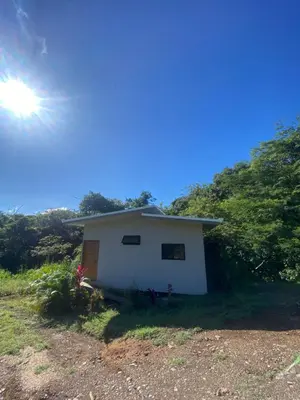 a small white house with the sun in the sky at Ona Casita 1 in Cuajiniquil