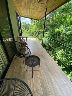 a screened porch with two chairs and a table at Ona Casita 1 in Cuajiniquil