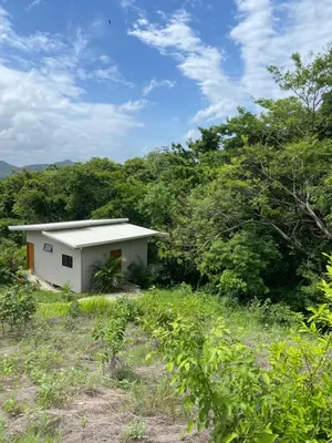 a small white building in the middle of a field at Ona Casita 1 in Cuajiniquil