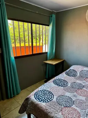 a bedroom with a bed and a window at Manzano lodge in Desamparados