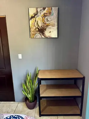 a table in a room with a painting on the wall at Manzano lodge in Desamparados