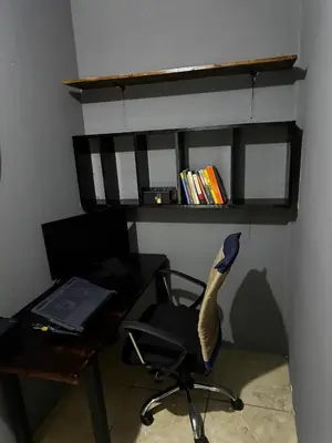 a office with a desk and a chair with a laptop at Manzano lodge in Desamparados