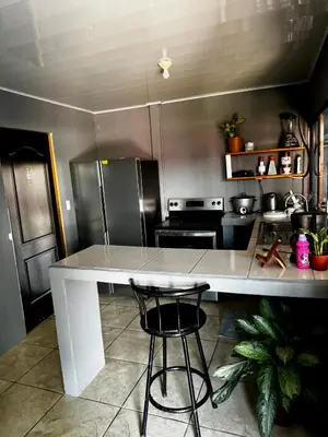 a kitchen with a large white island in a kitchen at Manzano lodge in Desamparados