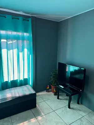 a living room with a flat screen tv and a couch at Manzano lodge in Desamparados