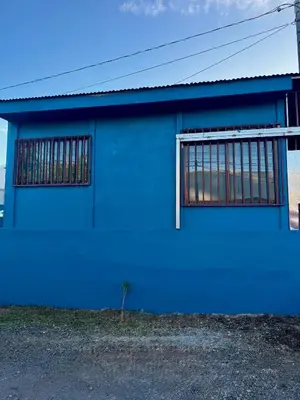 a blue building with a window on it at Manzano lodge in Desamparados