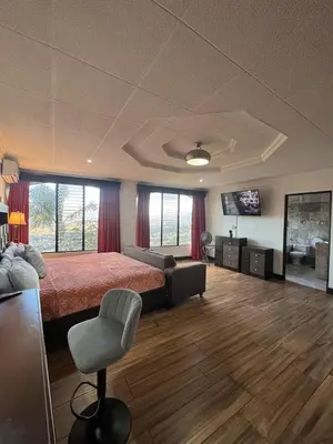 a bedroom with a bed and a couch and a television at Condomínio Vistas del Rio in San Antonio
