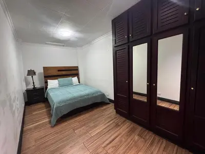 a bedroom with a bed and a wooden floor at Condomínio Vistas del Rio in San Antonio