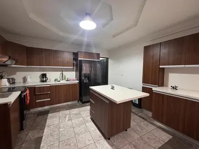 a large kitchen with wooden cabinets and a refrigerator at Condomínio Vistas del Rio in San Antonio