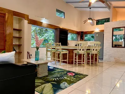 a kitchen and living room with a table and chairs at Zen Zaru Free MA Park Tour & Breakfast in Manuel Antonio