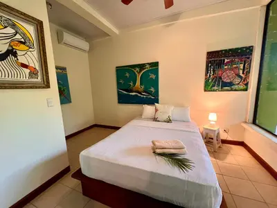 a bedroom with a large white bed in a room at Zen Zaru Free MA Park Tour & Breakfast in Manuel Antonio