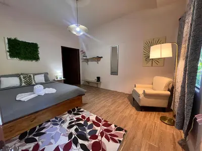 a bedroom with a bed and a couch and a chair at Zen Zaru Free MA Park Tour & Breakfast in Manuel Antonio