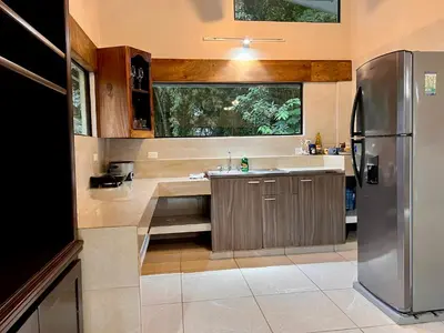 a kitchen with a sink and a refrigerator at Zen Zaru Free MA Park Tour & Breakfast in Manuel Antonio
