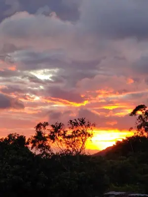 a sunset in the sky with trees in the foreground at Habitación Privada Casa Montaña Monteverde Tilarán in Sierra