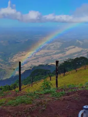 a rainbow on top of a hill with a field at Habitación Privada Casa Montaña Monteverde Tilarán in Sierra