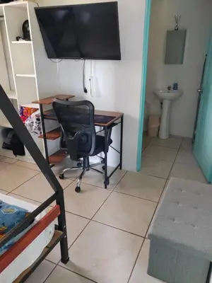 a desk with a chair and a television in a room at Habitación Privada Casa Montaña Monteverde Tilarán in Sierra