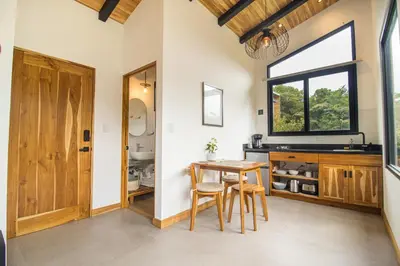 a dining room with a table and a window at MAUMA Forest Villas - Fireplace & Amazing Views in Monteverde Costa Rica
