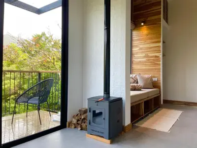 a wood stove in a living room with a couch at MAUMA Forest Villas - Fireplace & Amazing Views in Monteverde Costa Rica