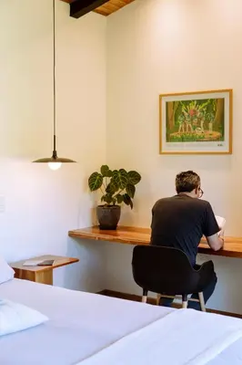 a man sitting at a desk in a bedroom at MAUMA Forest Villas - Fireplace & Amazing Views in Monteverde Costa Rica