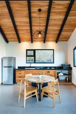 a kitchen with a table and chairs and a refrigerator at MAUMA Forest Villas - Fireplace & Amazing Views in Monteverde Costa Rica