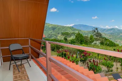 a chair on a balcony with a view of mountains at Bongalows Chepe Araya in Pejibaye