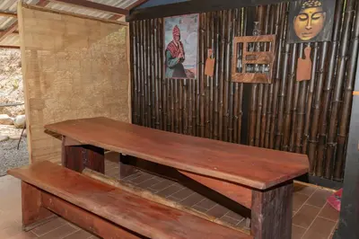 a wooden bench sitting in front of a wall at Cabaña Rustica Chepe Araya in Pejibaye