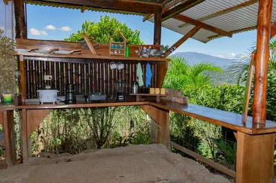 a wooden bar with a view of the mountains at Cabaña Rustica Chepe Araya in Pejibaye