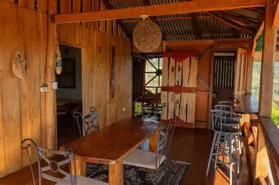 a dining room with a wooden table and chairs at Cabaña Rustica Chepe Araya in Pejibaye
