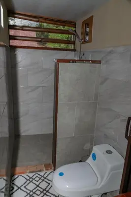 a bathroom with a shower with a toilet in it at Cabaña Rustica Chepe Araya in Pejibaye