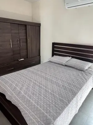 a bedroom with a large bed and a wooden cabinet at Ona Casita 2 in Matapalo
