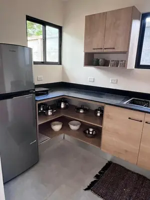 a kitchen with a refrigerator and two bowls in the floor at Ona Casita 2 in Matapalo