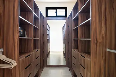 a walk in closet with wooden cabinets and a window at La Perla Cozy 3BR sleeps 10 Hacienda Pinilla in Santa Cruz