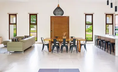 a dining room with a table and chairs and a couch at La Perla Cozy 3BR sleeps 10 Hacienda Pinilla in Santa Cruz