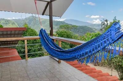a blue hammock on a balcony with a view at Villa Chepe Araya in Pejibaye