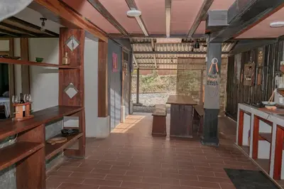 a room with wooden floors and a hallway with tables at Villa Chepe Araya in Pejibaye