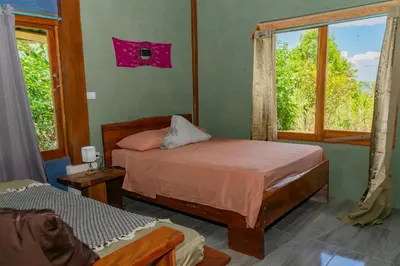 a bedroom with two beds and a window at Villa Chepe Araya in Pejibaye