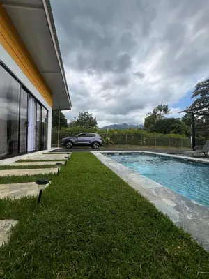a car parked next to a house with a swimming pool at Quinta La Esperanza in Chachagua