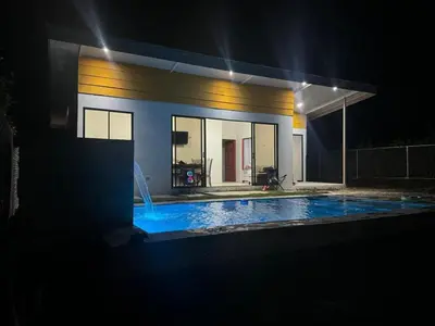 a house with a swimming pool at night at Quinta La Esperanza in Chachagua