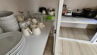 a kitchen with white mugs sitting on a shelf at Quinta La Esperanza in Chachagua