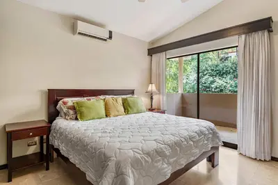 a bedroom with a large bed and a window at 2 BD Condo with Pool in Ocotal