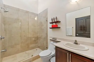 a bathroom with a toilet and a sink and a mirror at 2 BD Condo with Pool in Ocotal