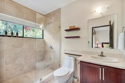 a bathroom with a toilet and a sink and a shower at 2 BD Condo with Pool in Ocotal