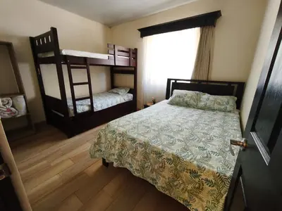 a bedroom with a bed and two bunk beds at SJO airport eco-Escape, Villa Lapa 5 & Pool in Tivives