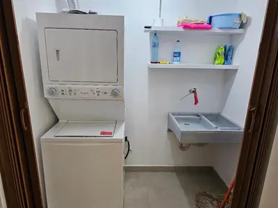 a bathroom with a washing machine and a sink at New House w Pool close to beach! in Esterillos Este