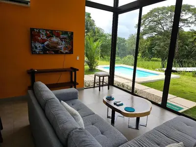 a living room with a couch and a table and a pool at New House w Pool close to beach! in Esterillos Este