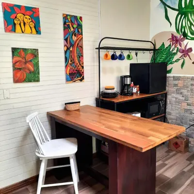 a kitchen with a wooden table and a chair at 2 Room 1 ba close to SJO airport, Poás and waterfalls in Alajuela City